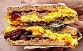 Breakfast Sandwich on an English Muffin With Charred Red Onions, Herbs, and Cheddar